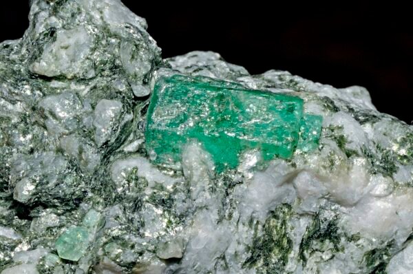 Bright green rough emerald crystal on pale matrix
