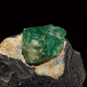 Rough emerald crystal set in dark and golden host rock
